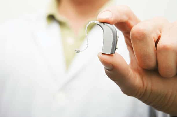 Doctor shows a last generation hearing aid device.More hearing and Ear health related files at: